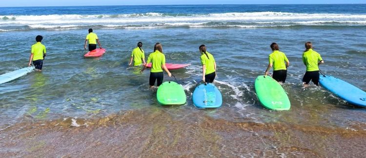 Supernova colonie ados groupe d'ados sur la plage coucher de soleil pays basque après cours de surf