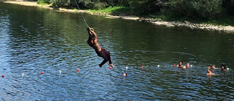 Supernova colonie de vacances enfant sur une tyrolienne au-dessus d'un plan d'eau ardèche